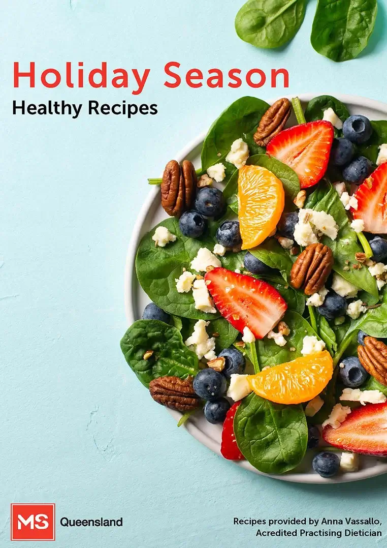 A colorful salad with spinach, strawberries, blueberries, orange slices, pecans, and crumbled cheese on a white plate, with the text "Holiday Season Healthy Recipes" on a light blue background.