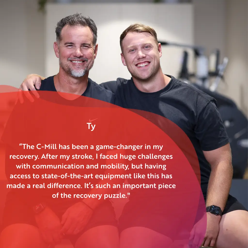 Two men sit close together, smiling at the camera in a gym setting. A testimonial about stroke recovery from Ty, mentioning the value of specialized equipment, is overlaid on the image in white text.